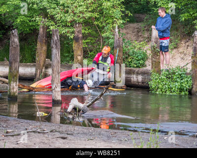 Józefów, Poland - May 12: canoeing, extreme kayaking. The guy in a small sport kayak is practicing with coach how to overcome a difficult obstacle on Stock Photo