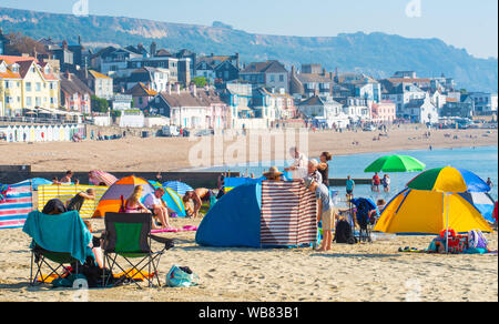 Lyme Regis, Dorset, UK. 25th Aug, 2019. UK Weather: Blisteringly hot sunshine and swelterig heat as temperatures soar further on Bank Holiday Sunday. Beachgoers secure a spot on the sandy beach at picturesque Lyme Regis before bank holiday crowds hit the popular seaside resort. Credit: Celia McMahon/Alamy Live News Stock Photo