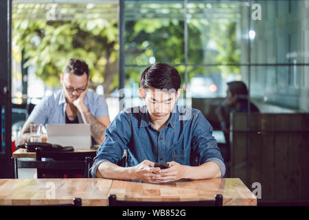Man using mobile phone in the restaurant Stock Photo
