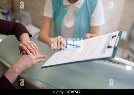 Receptionist of dentistry showing the form to fill in and sign Stock Photo