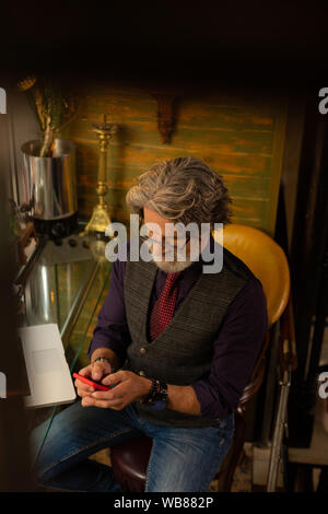 Concentrated man writing messages to his colleagues. Stock Photo