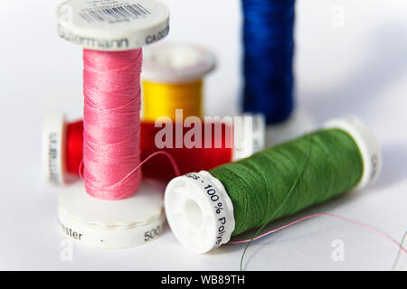 Umea, Sweden - August 15, 2019: sewing thread on reel in different colors on white background Stock Photo