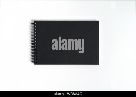 Notebook mock up with clean black blank for design and advertising. Notepad with chromed spring and free copy space template. On the gray background. Stock Photo
