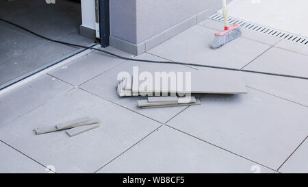 Tiler worling by laying new tiles on a house entrance Stock Photo