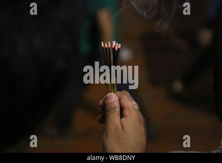 Lalitpur, Nepal. 24th Aug, 2019. A devotee offers prayers with burning incense sticks in celebration of Bhimsen Jatra or Bhimsen Festival at Patan Durbar Square in Lalitpur. (Photo by Archana Shrestha/Pacific Press) Credit: Pacific Press Agency/Alamy Live News Stock Photo