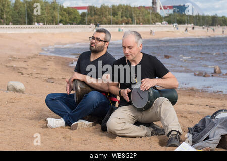 Saint-Petersburg, Russia. August 24, 2019: Street musicians play drums on the beach. Stock Photo