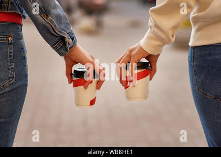 Two woman hand with paper cup of coffee takea way in city street Stock Photo