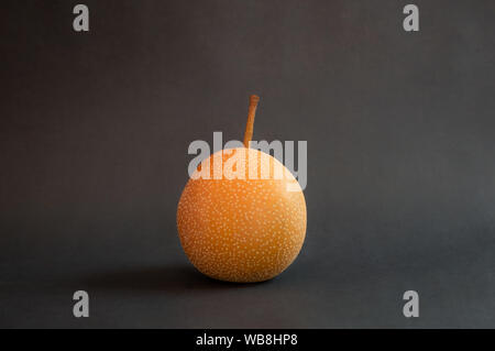 Fresh Nashi or Asian pears isolated on dark background. Close up of Pyrus Pyrifolia, rare type of fruit on dark background. Stock Photo