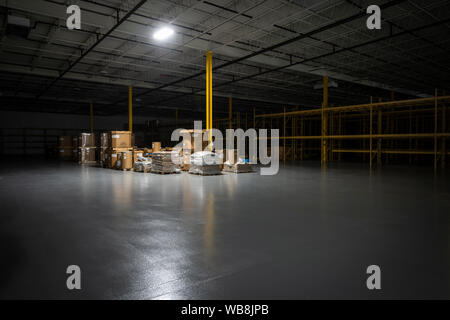 Sparse Inventory In Dark Warehouse At Night Stock Photo