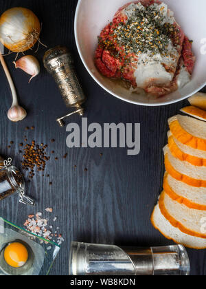 minced meat, meat patties, rissole Ingredients: raw minced meat , raw egg, chopped onion,garlic, bread, herbs, salt and pepper on wooden background Stock Photo