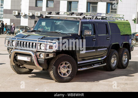 Firm 'Nizhegorodets.' A three-axle, black, chrome-plated Hummer car, stands near the salon. Russia Stock Photo