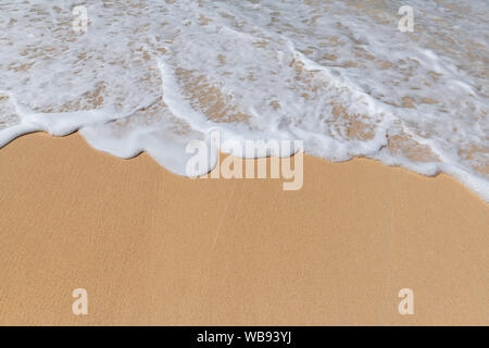 Soft ocean waves with foam on the sandy beach. Stock Photo