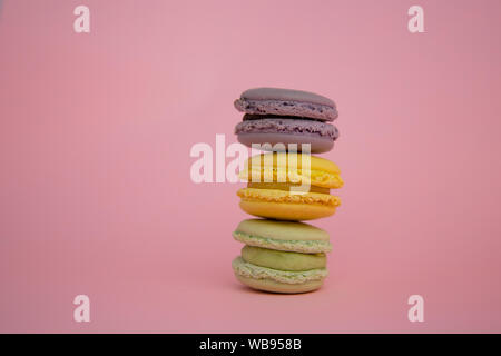 Three French macaroons stacked on top of each other with pink background Stock Photo
