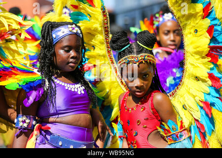 Kid dancers in costumes during the children parade on the family day of Notting Hill Carnival in west London.Thousands of revellers take part in Notting Hill Carnival, Europe's largest street party and a celebration of Caribbean traditions and the capital's cultural diversity. Stock Photo