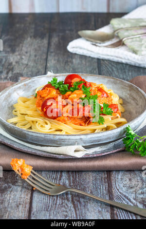 Chilli crab and cherry tomato linguine pasta Stock Photo - Alamy