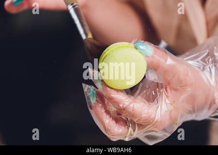 Different sweet fresh french macarons in girls hand Stock Photo