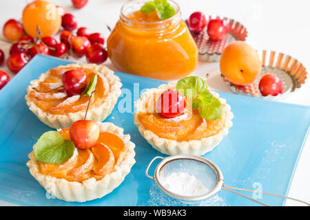 Apricot tarts with sherries and mint leaves Stock Photo