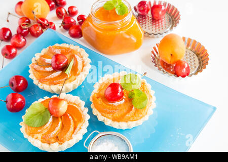 Apricot tarts with sherries and mint leaves Stock Photo