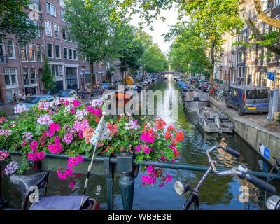 Amsterdam, Netherlands - July 19, 2018: Views along the Egalantiersgracht Canal in the Jordaan District of Amsterdam. There are many bridges with flow Stock Photo