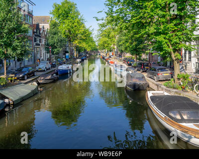 Amsterdam, Netherlands - July 19, 2018: Views along the Egalantiersgracht Canal in the Jordaan District of Amsterdam. There are many bridges with flow Stock Photo