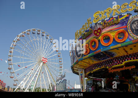 Worms, Germany. 24th August 2019. A Ferris wheel and the Music Express 300 ride at the Backfischfest 2019. The largest wine and funfair along the river Rhine, the Backfischfest started in Worms with the traditional handing over of power from the Lord Mayor to the mayor of the fishermen’s lea. The ceremony was framed by dances and music. Stock Photo