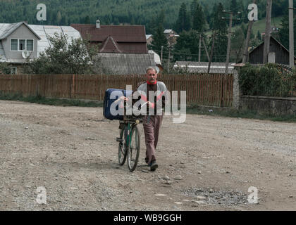 Man with and old bicycle walking after work. Stock Photo
