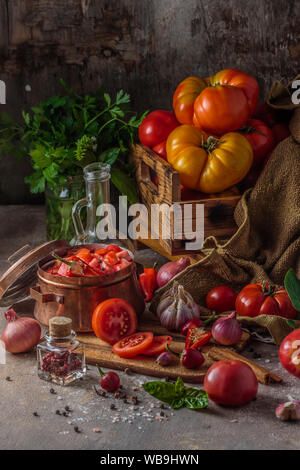 Sliced fresh tomatoes on cutting board, dark photo. Stock Photo
