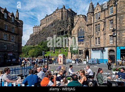 Diners eating outside in the Grassmarket with a view of Edinburgh Castle in the Background. Stock Photo