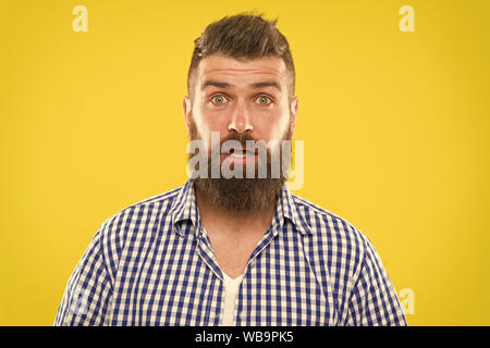 Hipster with beard and mustache emotional surprised expression. Rustic surprised macho. Surprising news. Man bearded hipster wondering face yellow background close up. Guy surprised face expression. Stock Photo