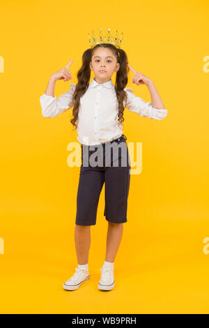 Look who is a big boss here. Little big boss on yellow background. Cute girl boss wearing crown. Small child with big ambitions. Adorable boss lady being serious for dreaming big. Stock Photo