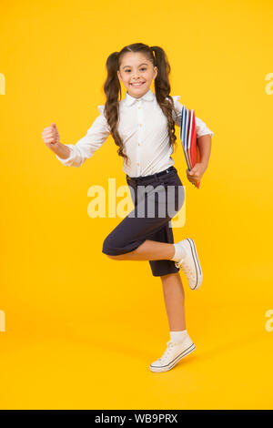 Hurry up. Keep going. Active kid. Girl with books on way to school. Knowledge day. Back to school. Kid cheerful schoolgirl running. Pupil want study. Active child in motion. Beginning school lesson. Stock Photo