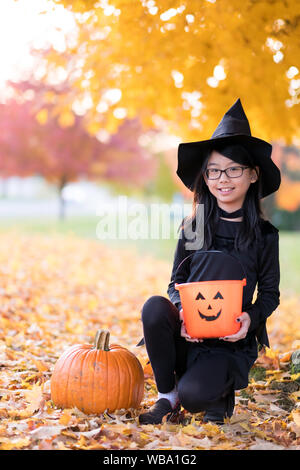 Portrait of little asian girl in witch costume Stock Photo