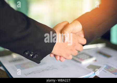 shaking hand concept / two successful asian business women shake hands people in need of exchange and cooperation finishing up meeting in a office Stock Photo