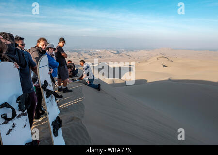 Tourists with sandboards, Huacachina desert oasis, Ica, Peru Stock Photo