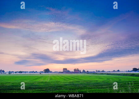 Colorful glowing sunrise over a countryside farming area, creating an idyllic scenic landscape Stock Photo