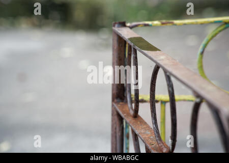 Rusty iron fence with damaged steel circles Stock Photo