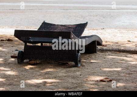 Old folding chairs under the shade of trees on the beach in the daytime of Thailand Stock Photo