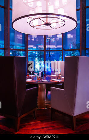 FEB 27, 2014 Dalat, Vietnam - Modern luxury design armchair and fine dining dinner table in hotel restaurant. Modern furniture with dinner table set w Stock Photo