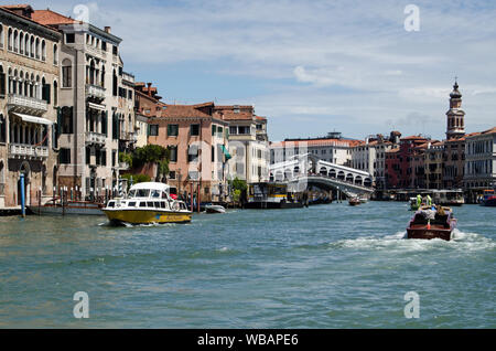 Venice, Italy - May 16, 2019: View from the north bank of the Grand Canal in Venice looking towards the famous Rialto Bridge on a sunny Spring day. Stock Photo