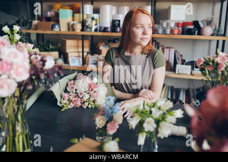 Florist waiting for customer in flower shop Stock Photo