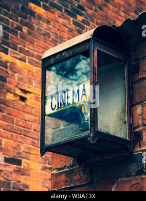 Old cinema sign hanging on brick wall Stock Photo