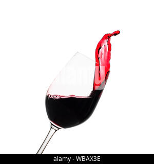 Freeze motion splash of red wine in an elegant tilted wineglass isolated on white with copy space Stock Photo