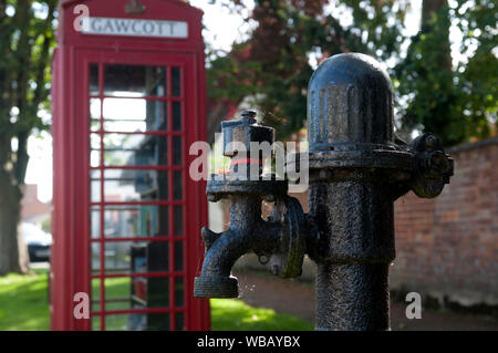 The old village pump and telephone box, Gawcott village, Buckinghamshire, England, UK Stock Photo