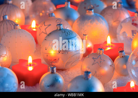 Silver Christmas baubles and burning small, star shaped candles. Studio picture. Switzerland Stock Photo