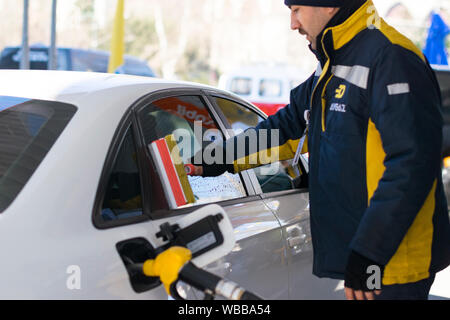 Hand wash car window Cleaning the car side glass. Windscreen washer at gas station. Stock Photo