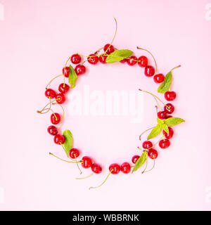 Cherry with mint leaves on light on a pink background. Stock Photo