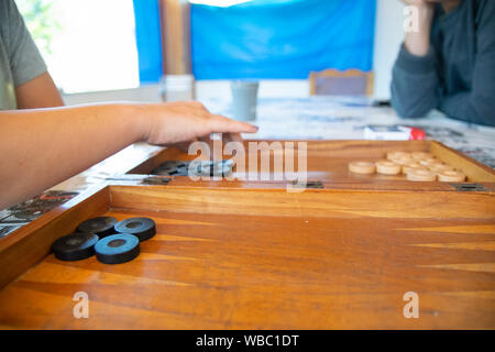 Playing backgammon on a wooden table with dices. Stock Photo