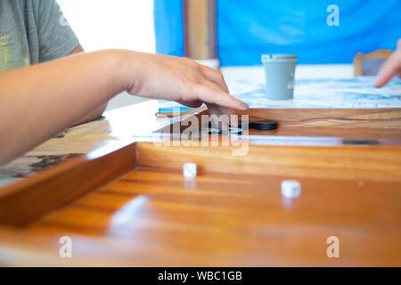 Backgammon game. The player's hand moves the chip, closeup Stock Photo