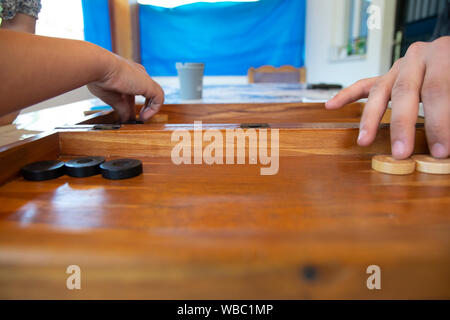 Backgammon game. The player's hand moves the chip, closeup Stock Photo