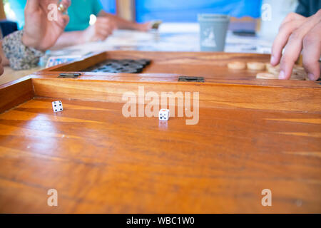 Playing backgammon on a wooden table with dices. Stock Photo